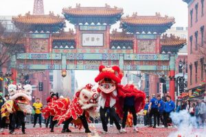 A Chinese dragon dances before the Chinatown arch in Downtown DC